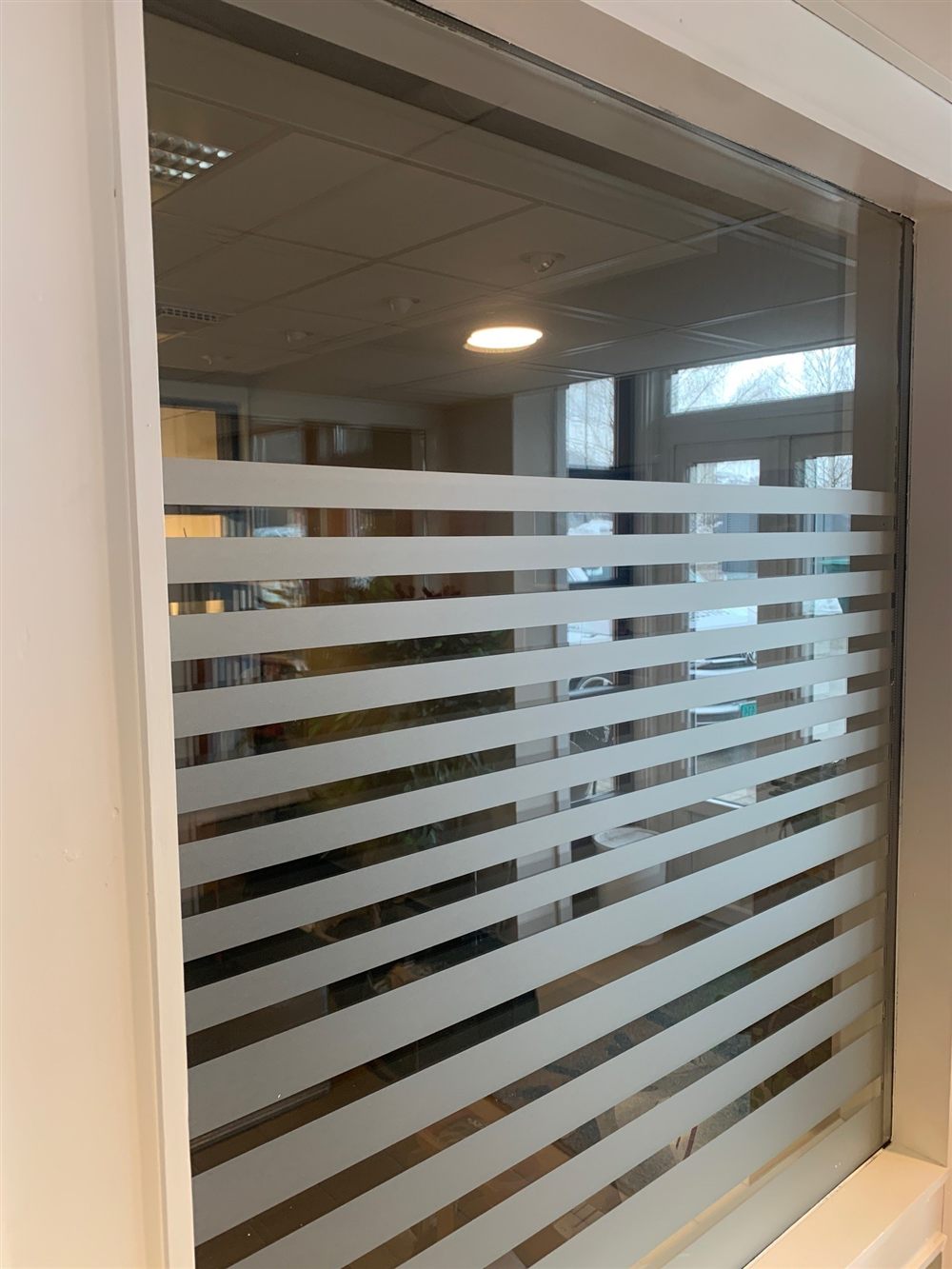 Frostet folie med skårne striper på kontorvindu